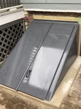 A gray metal door is sitting on top of a concrete platform.