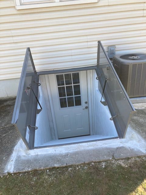 A basement door with the door open and a window.