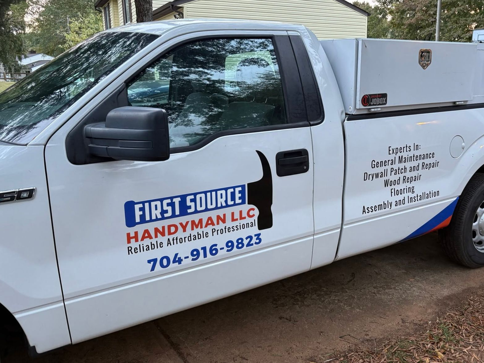White First Source Handyman Services pickup truck parked outdoors with company logo on the door