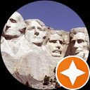 A group of statues of presidents are sitting on top of a mountain.