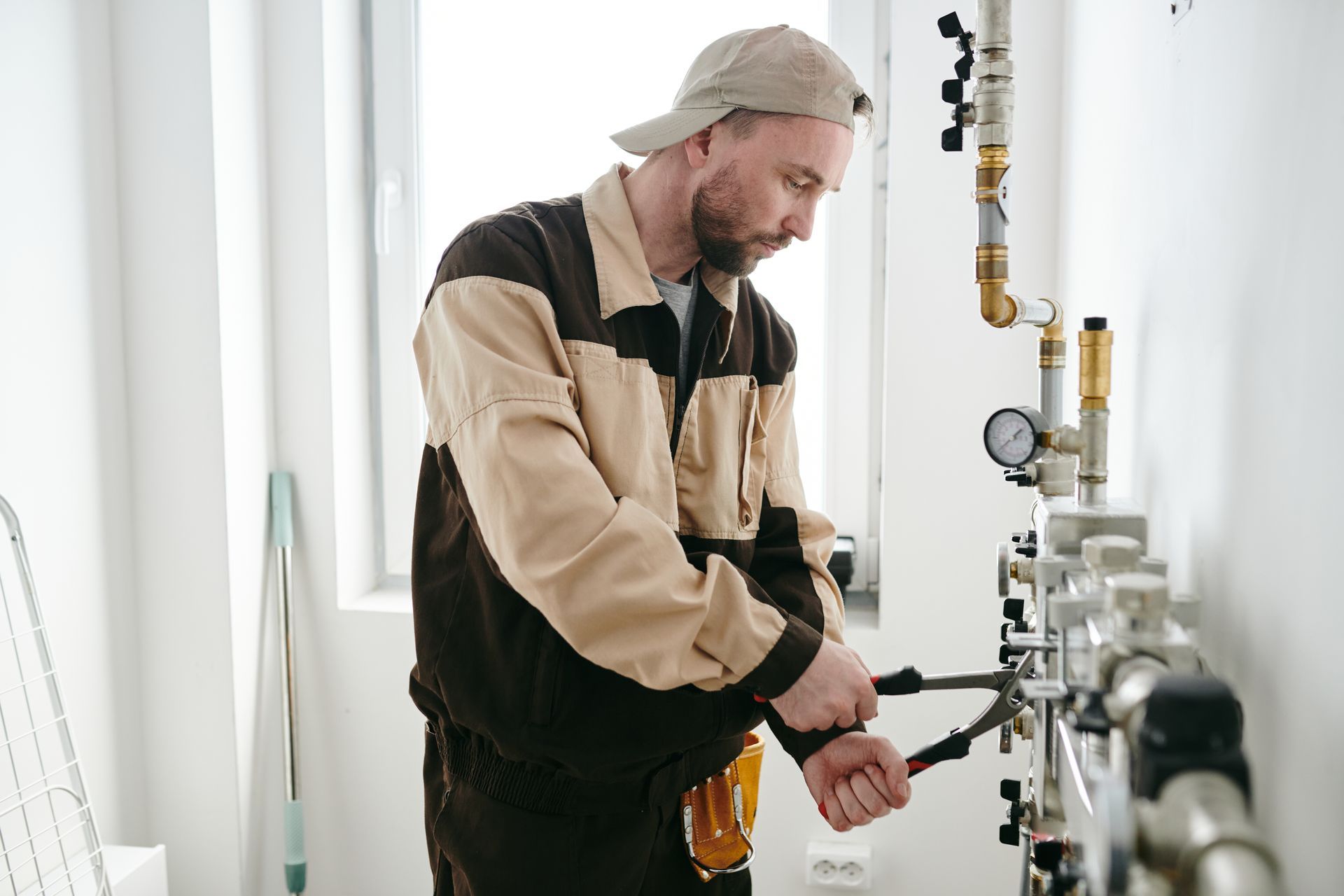 A man is working on a pipe with a wrench.