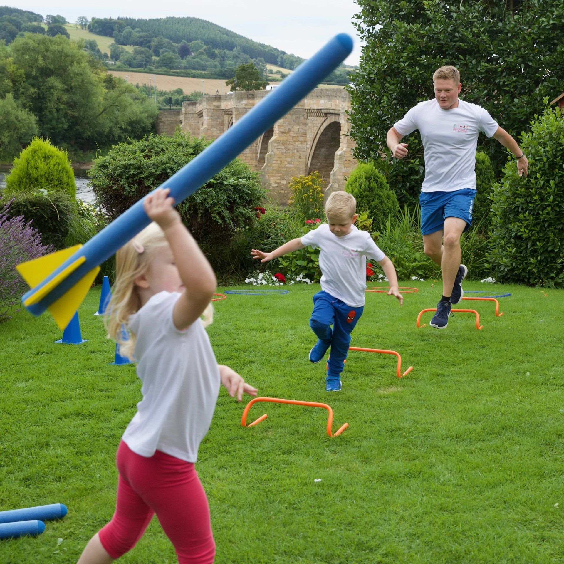 A little girl is holding a blue foam stick in her hand