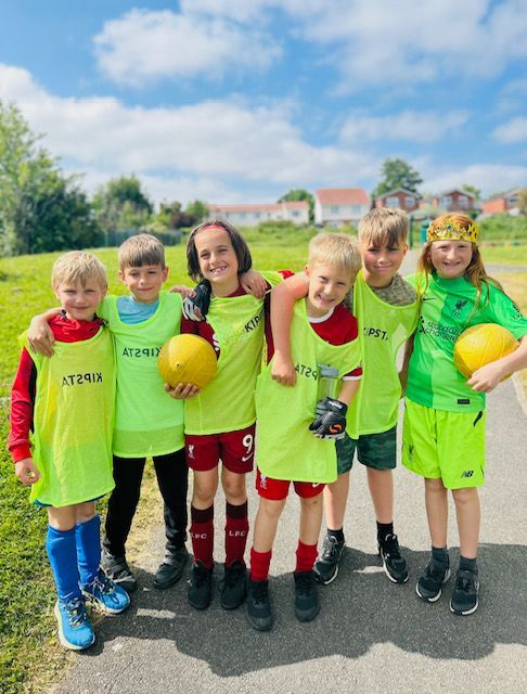 A group of young boys are posing for a picture while holding soccer balls.