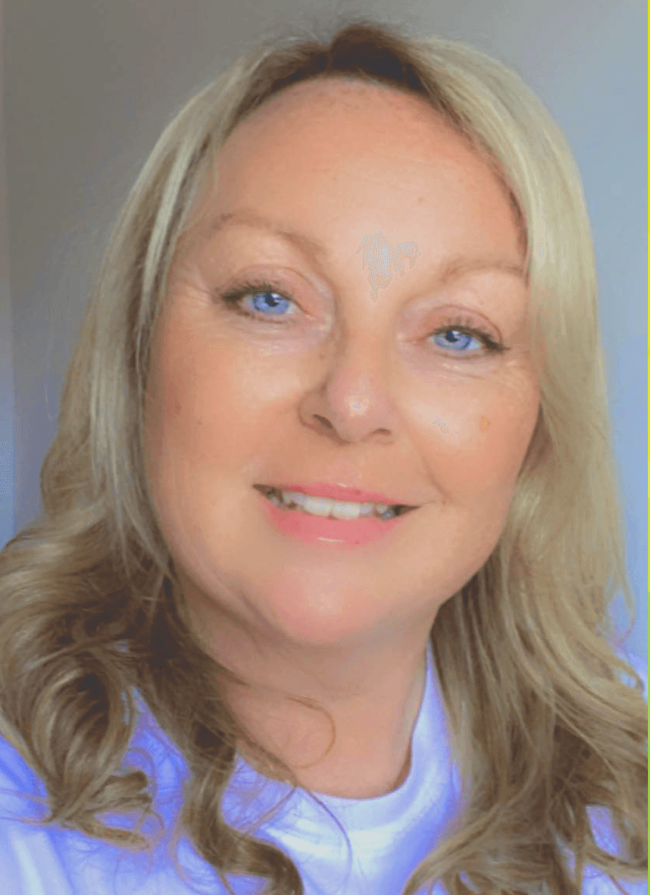 A woman with blonde hair and blue eyes is smiling for the camera.