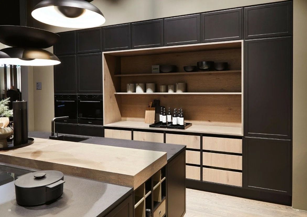 Modern kitchen with dark cabinets, wood shelves, and a large island under pendant lights