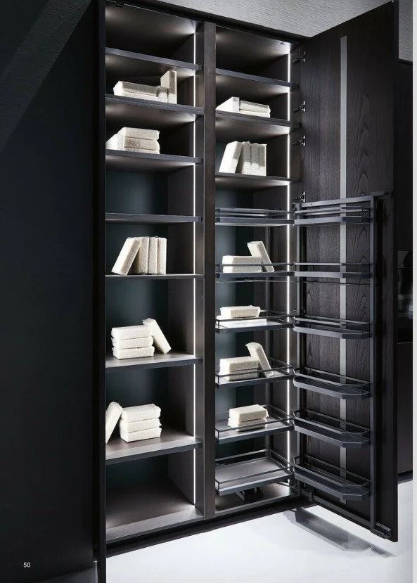 Black built-in cabinet with open shelves holding folded linens and wire pull-out baskets.