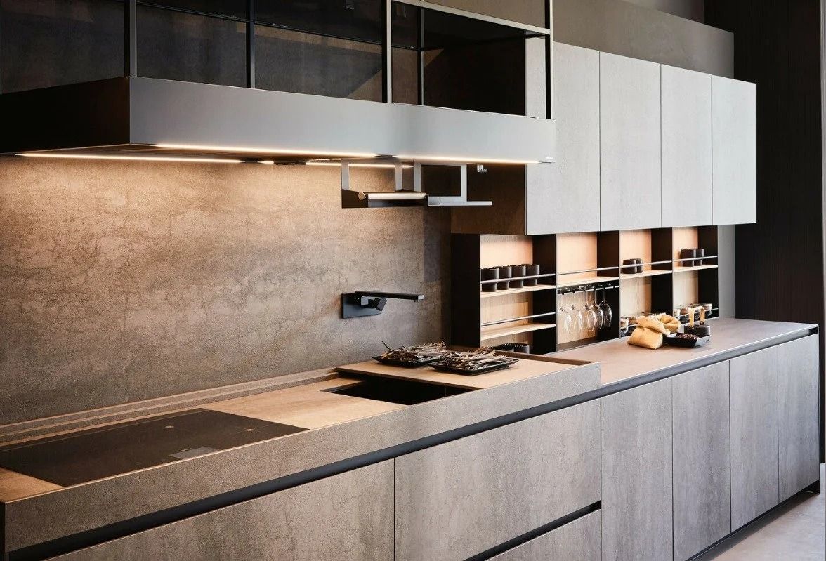 Modern minimalist kitchen with gray cabinets, stone backsplash, and built-in appliances.