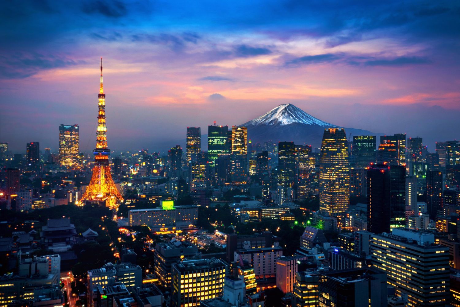 Tokyo skyline at dusk with Tokyo Tower glowing and Mount Fuji silhouetted in the distance
