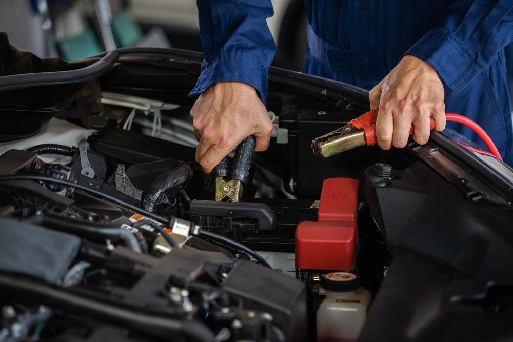 An Mechanic Using Jumper Cables — Woden Automotive Services in Phillip, ACT