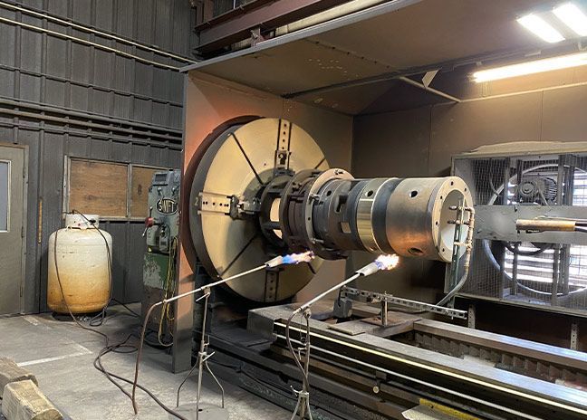 Part being coated using thermal spray.