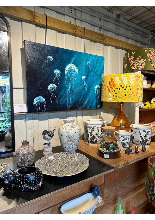 A Painting Of Jellyfish Is Hanging On A Wall Above A Table — Burnetts On Barney in Kiama, NSW