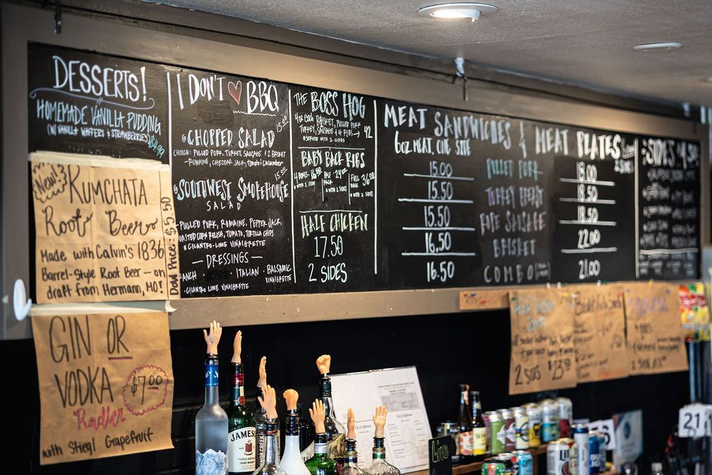 Cafe chalkboard menu with desserts, drinks, and food specials above a counter