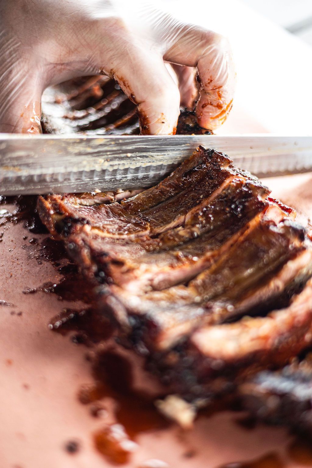 Hand slicing a chocolate-glazed layered cake close-up