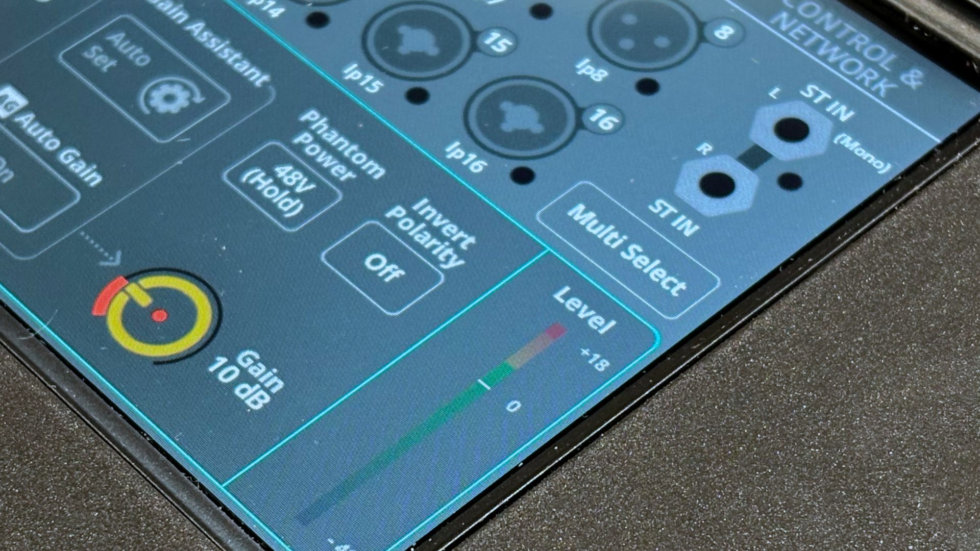 Close-up of an Allen & Heath CQ-18T digital audio mixer panel with knobs, switches, and a level meter on a dark surface.