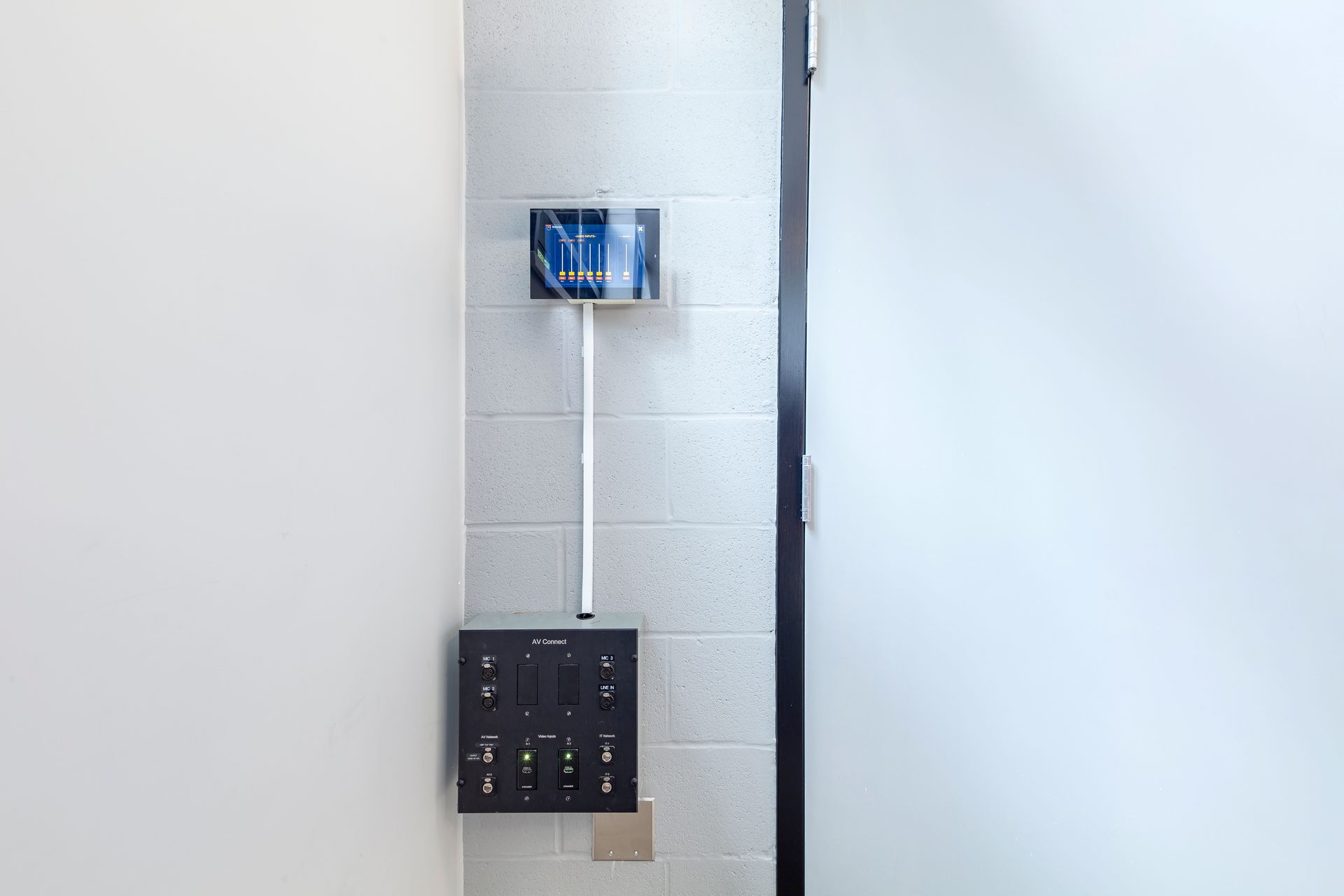 A wall with a blue and white patterned object, a control panel, and a door.