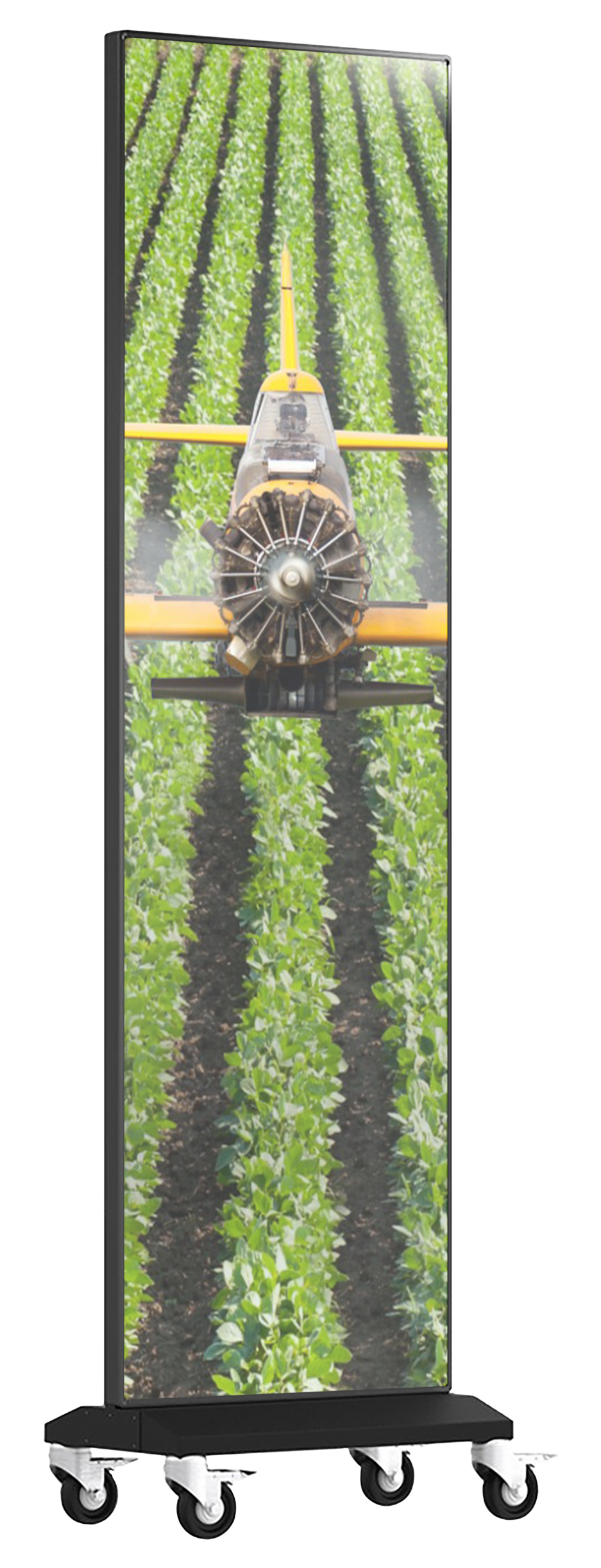 A yellow crop duster plane spraying a green field, mounted on a mobile display stand.