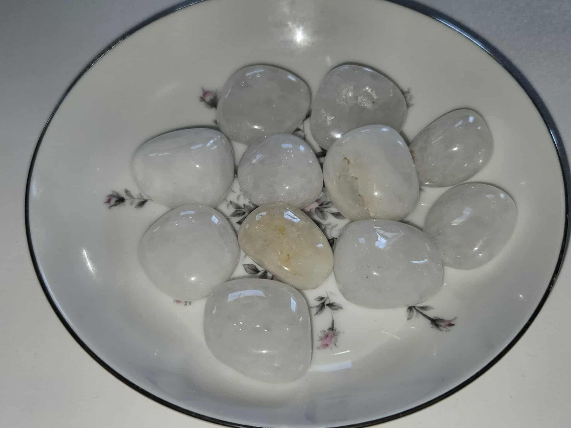 White tumbled stones in a decorative floral dish.