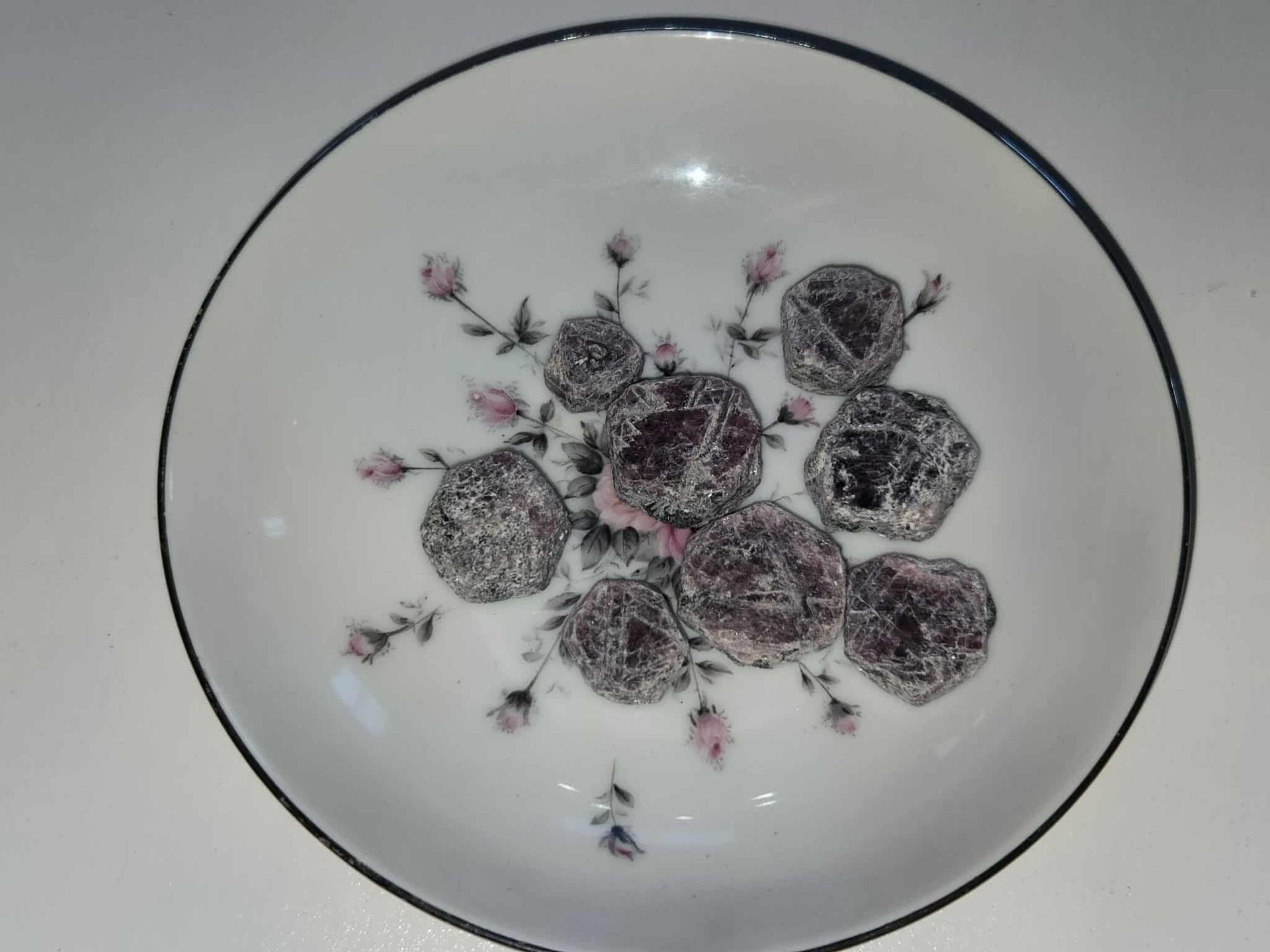 Bowl of sugared plums on a floral patterned plate.
