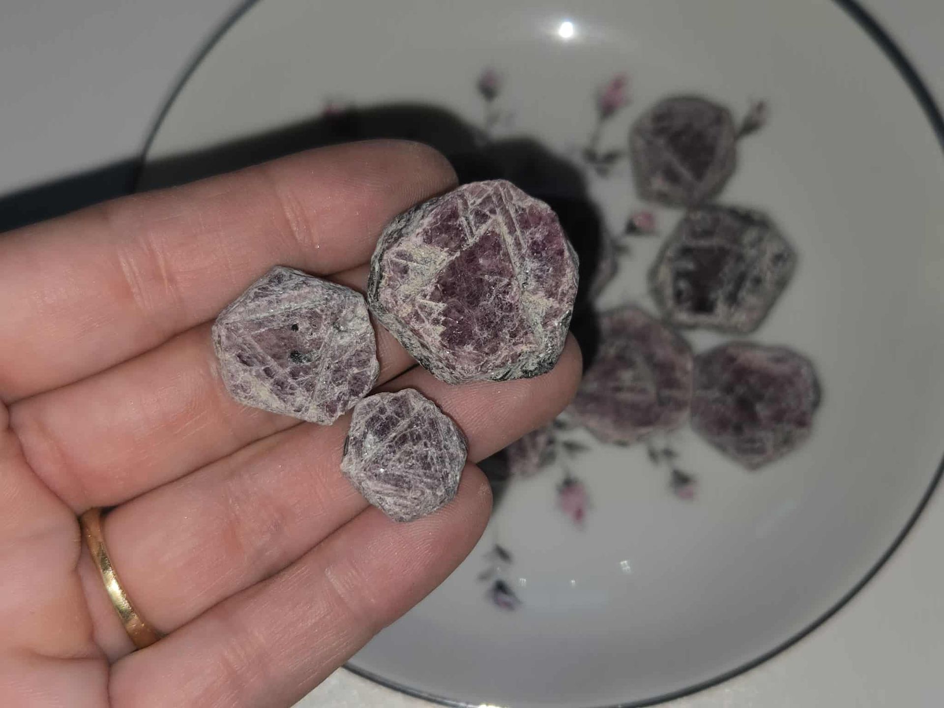 Bowl of sugared plums on a floral patterned plate.