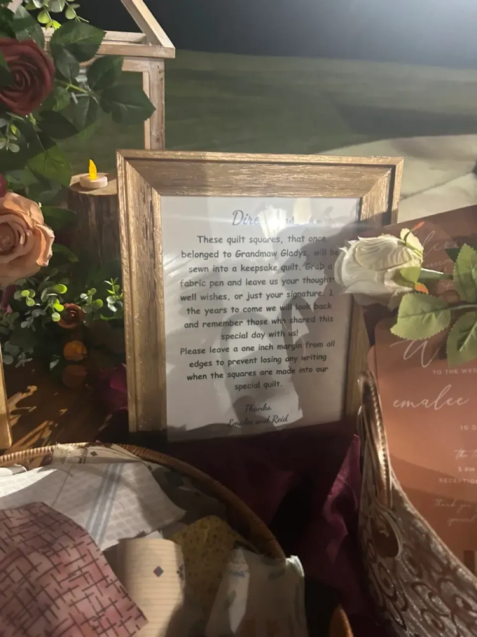 Framed printed note among roses and candles on a burgundy tablecloth