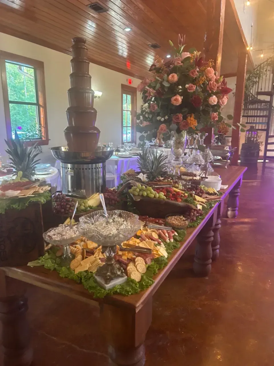 Long buffet table with floral centerpiece and assorted dishes in a warmly lit dining room