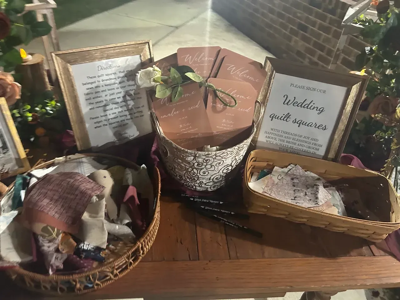 Gift basket display with wrapped treats, floral accents, and handwritten signs on a table