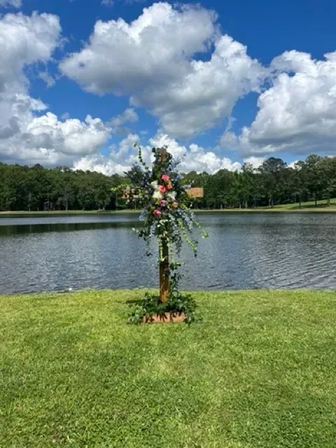 Flowered young tree by a lake under a blue sky with clouds