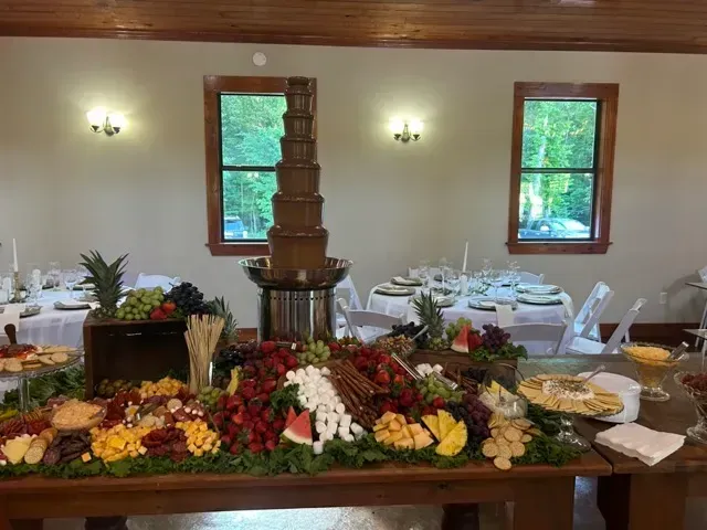 Banquet table with colorful flowers and a tall chocolate fountain in a bright dining room