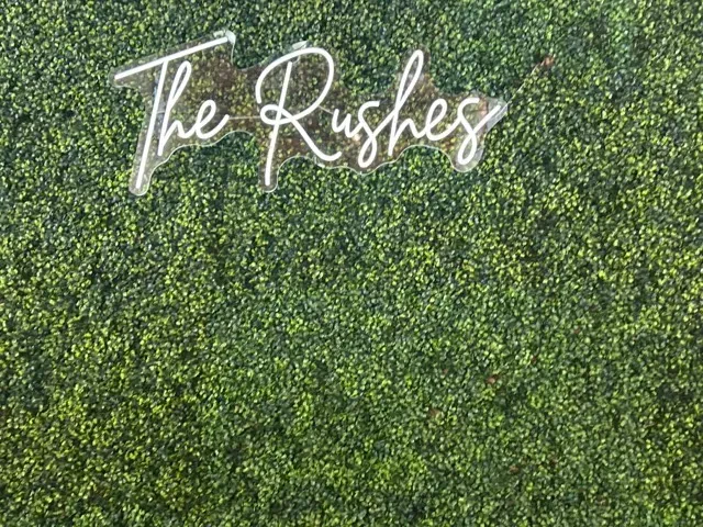 White script reading “The Rushes” on a green leafy background