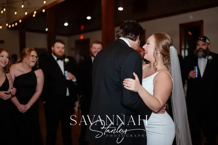 Bride and groom sharing a dance at a reception, guests watching in the background