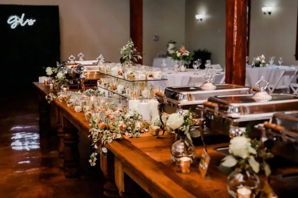 Long banquet table with flowers, candles, and serving dishes at a formal event