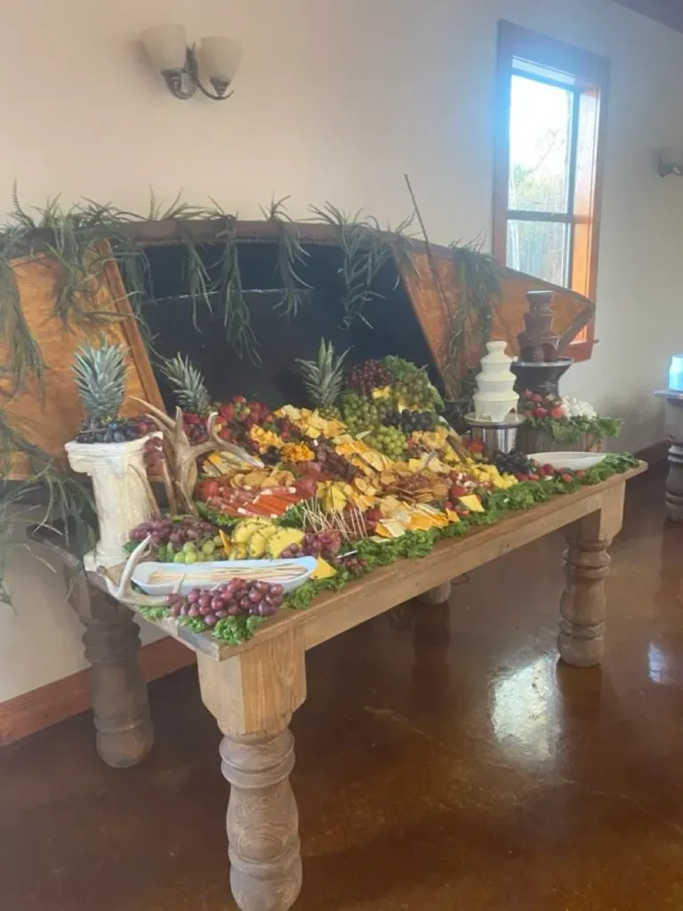 Decorated wooden table with a fruit display and green plants in a bright indoor room