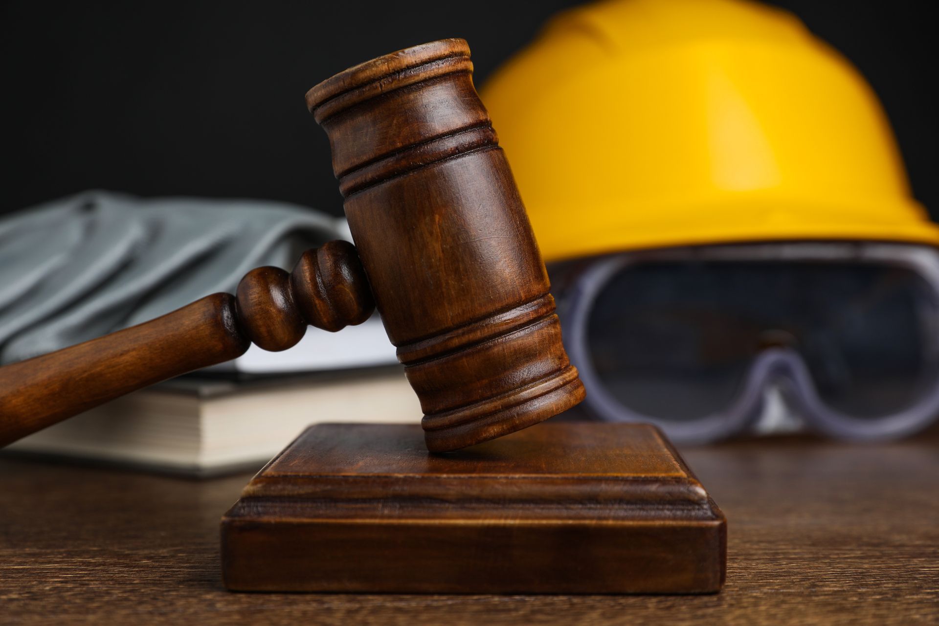 Accident at work with gavel, safety gear, and books on table.
