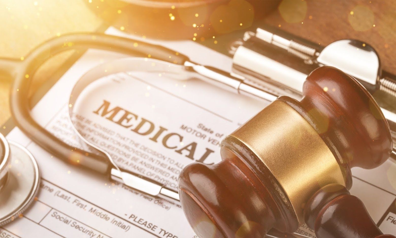 Stethoscope, gavel, and medical document on a wooden surface, symbolizing healthcare law.
