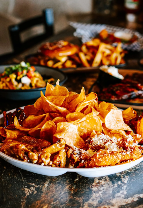 Assorted food on a table: chips, fried chicken, burger, fries, and salad.