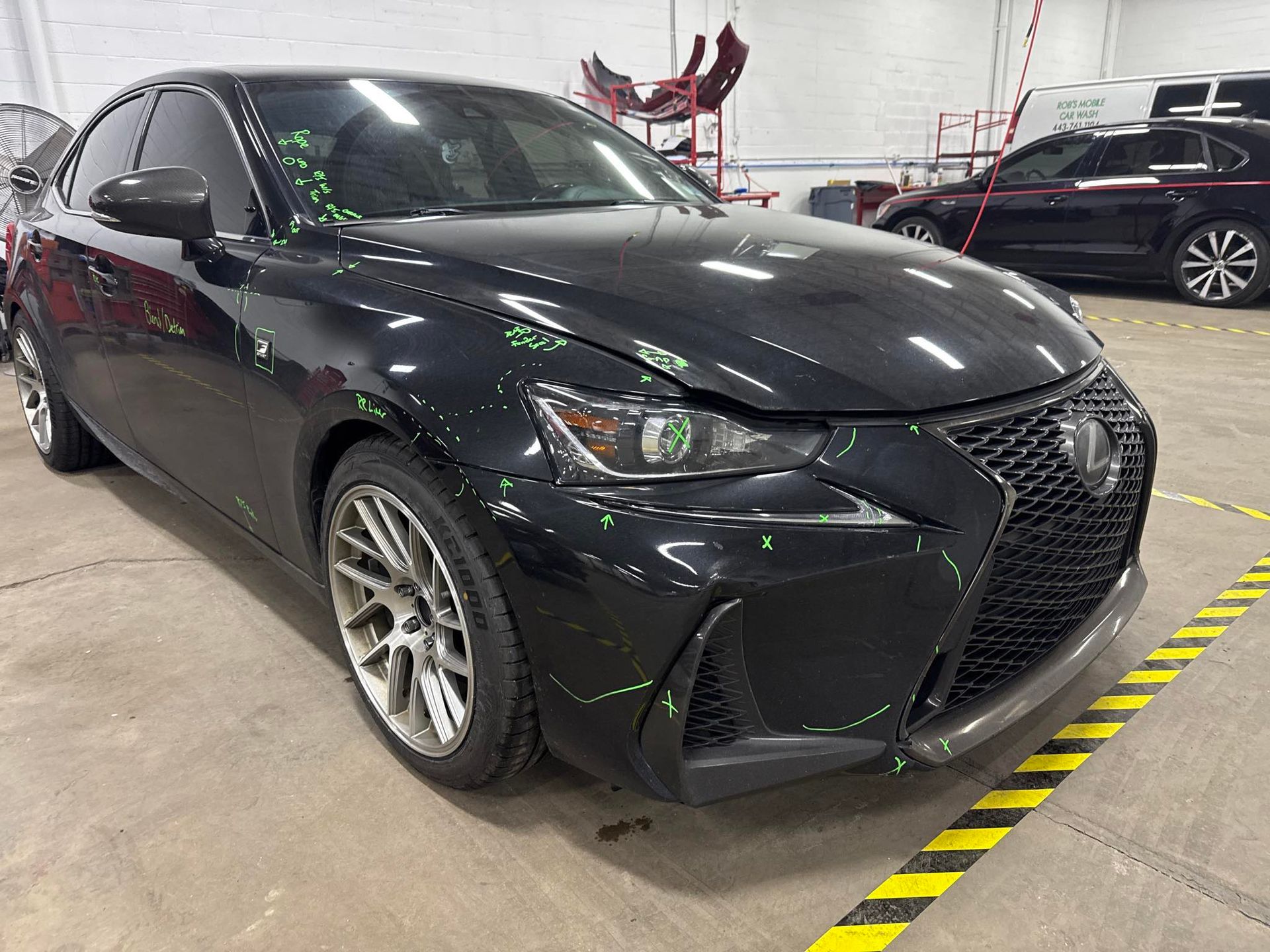 Black Lexus in shop with markings