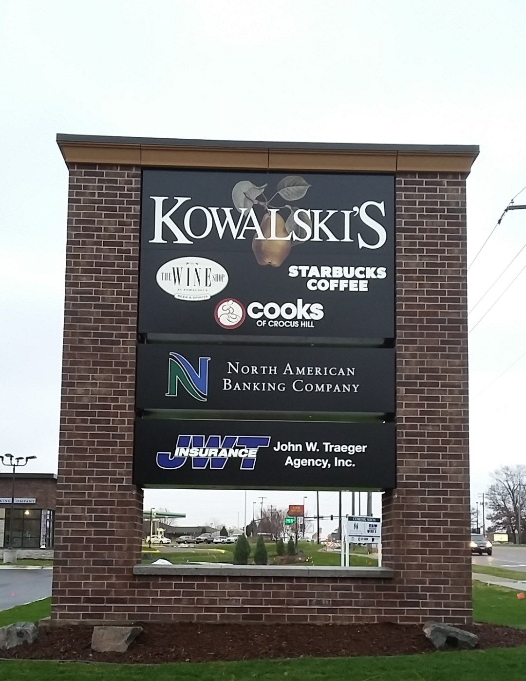 Sign with business names: Kowalski's, Starbucks Coffee, Cooks, North American Banking Company, and John W. Truman Agency, Inc. Sign with business names: Kowalski's, Starbucks Coffee, Cooks, North American Banking Company, and John W. Truman Agency, Inc.