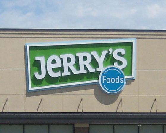 Jerry's Foods sign with white text on a green background, blue border, and a small blue circle with 