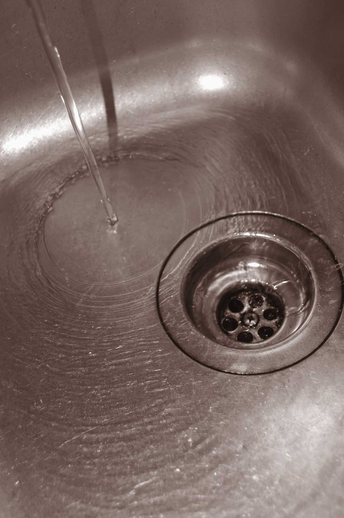A sink faucet and drain with running water