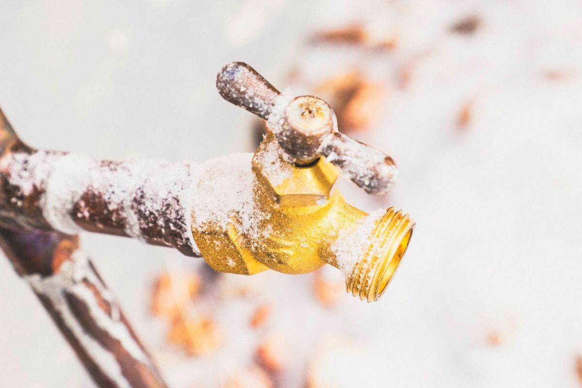 Icy outdoor water faucet with frost on the handle and spout
