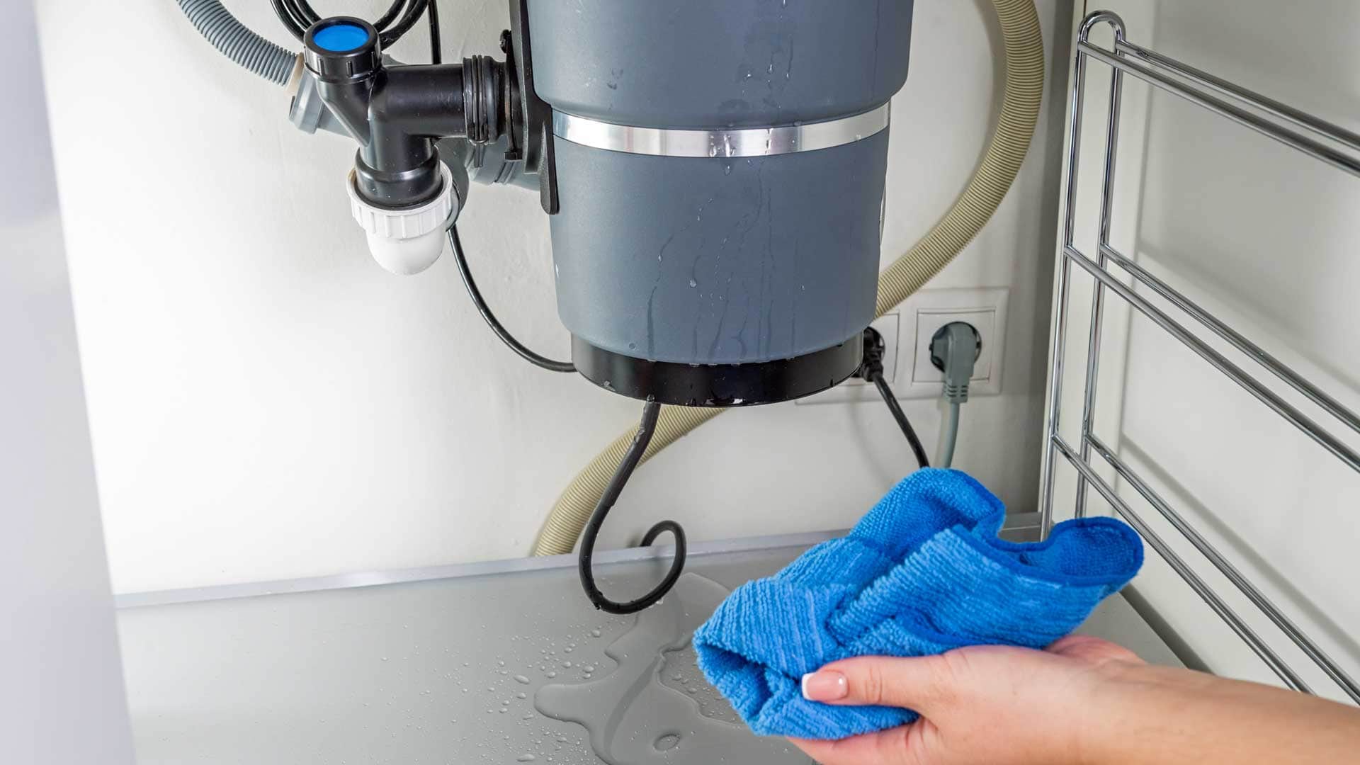 Blue cloth wiping the underside of a gray machine in a clean workshop