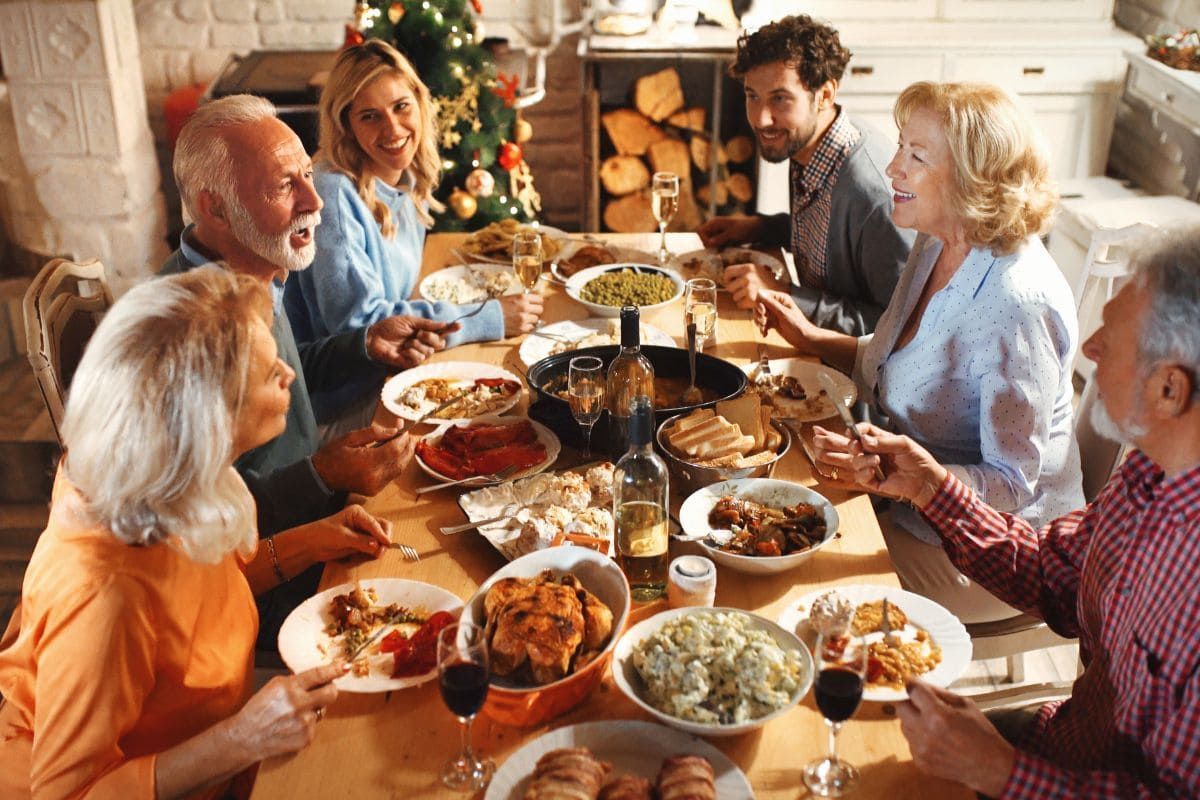 Family gathered around a festive dining table, sharing a holiday meal and conversation.