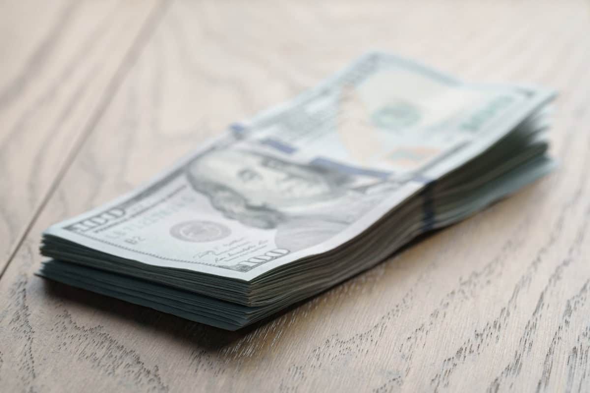 Stack of U.S. dollar bills on a wooden surface