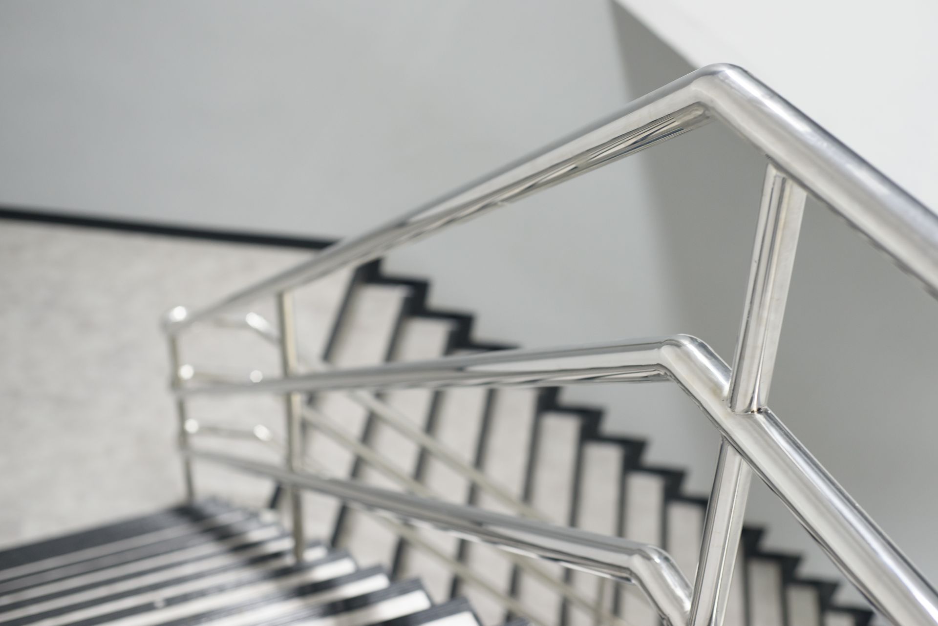 Metal stair railing with geometric lines in a modern indoor stairwell