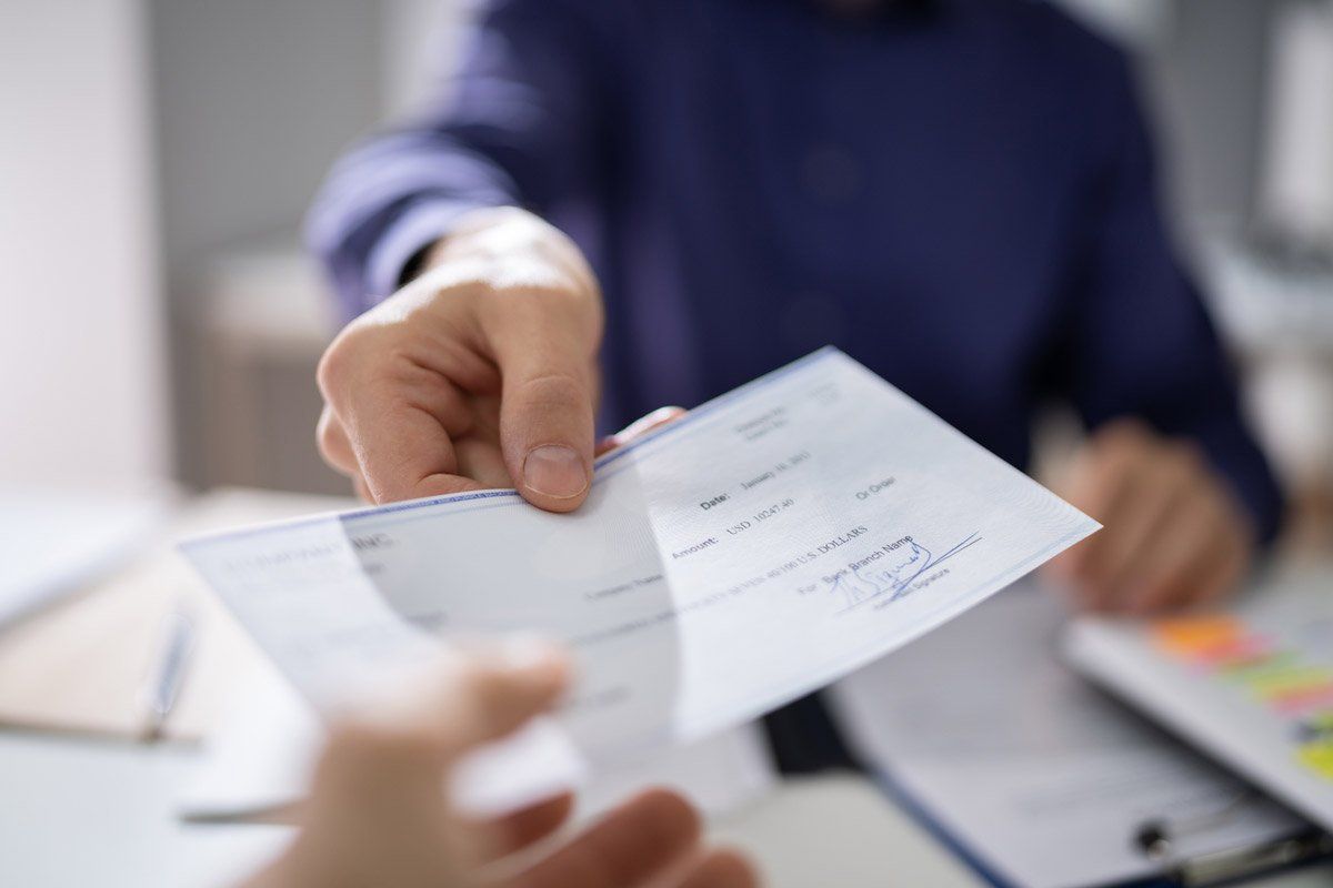 Person Hands Giving Cheque — Savannah, GA — Discount Check Casher Person Hands Giving Cheque — Savannah, GA — Discount Check Casher