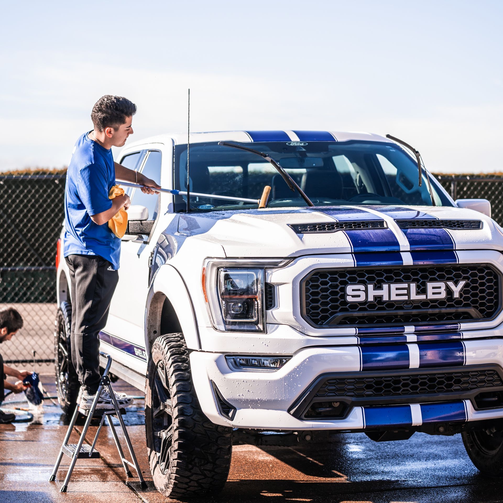 KeptCar detailer washing a white Shelby F-150 truck