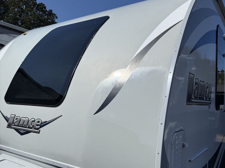 Travel trailer fiberglass front cap restored to a gloss finish after oxidation removal and polish