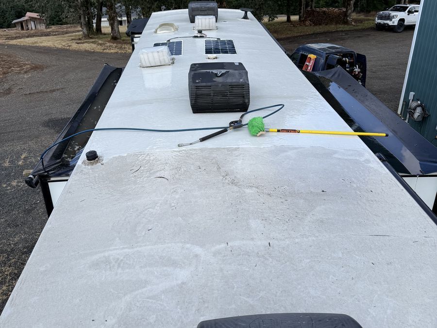 RV roof halfway through cleaning, showing the clean section next to the dirty section