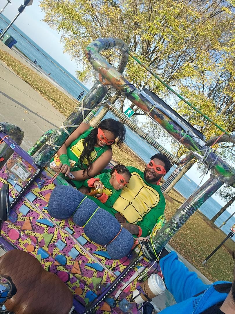 A family dressed as Ninja Turtles enjoys a fun, themed pedicab city tour, a unique option for those searching for family-friendly pedicab tours near me.