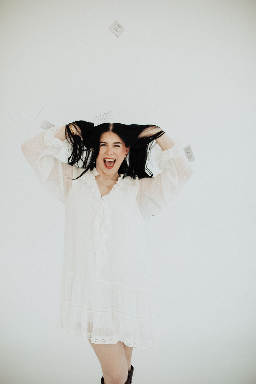 Woman in white dress, hands in hair, excited expression; money falling.
